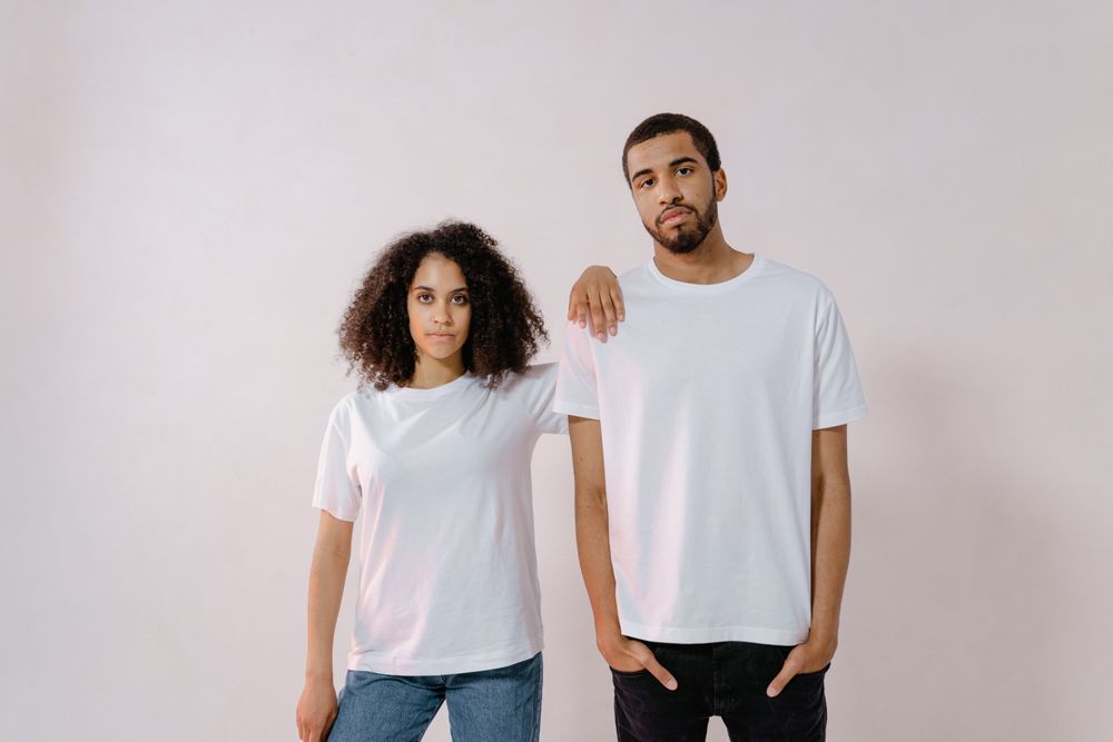 Dos modelos con playeras blancas, referencia de estilo casual